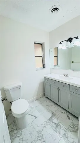 a spacious bathroom with a toilet sink and mirror