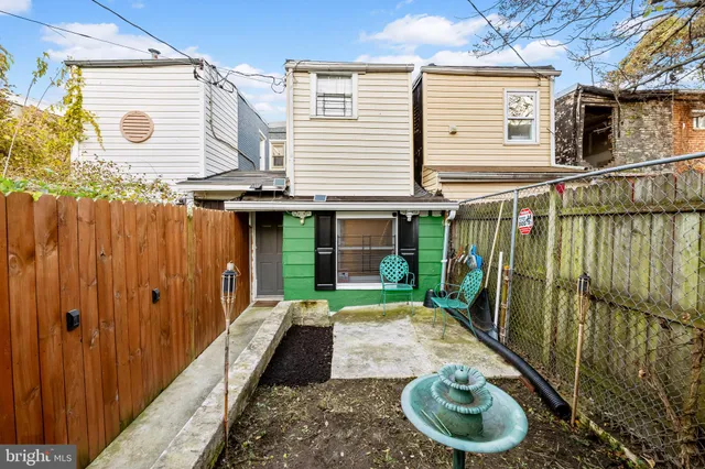 a view of a house with a tub and wooden bench in a patio