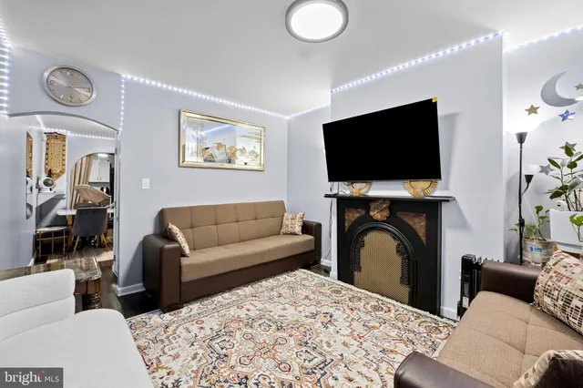 a living room with furniture a flat screen tv and a fireplace