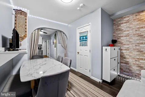 a living room with a table chairs and entryway