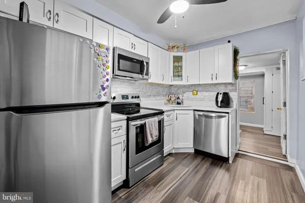 a kitchen with white cabinets stainless steel appliances and sink