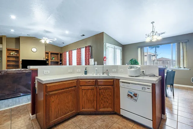 a kitchen with stainless steel appliances a sink cabinets and a window