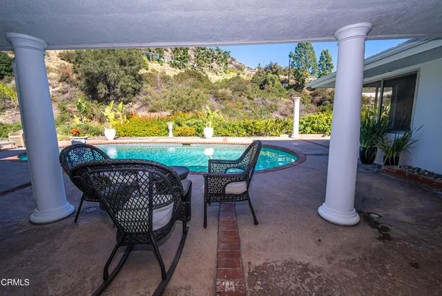 a view of a hallway with wooden floor and a bathroom