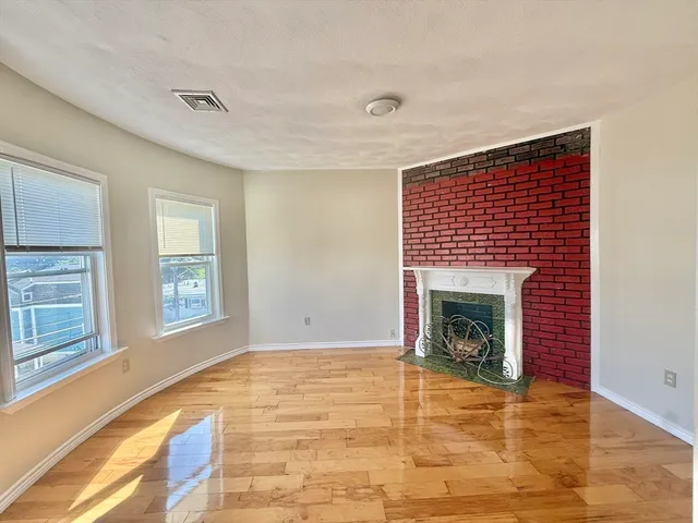 a view of an empty room with a fireplace and a window