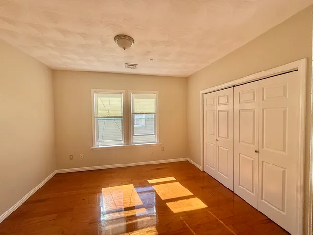 a view of an empty room with a fireplace and a window