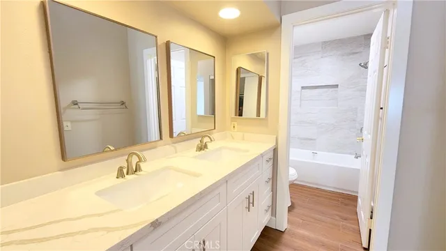 a bathroom with a granite countertop sink a mirror and a bathtub