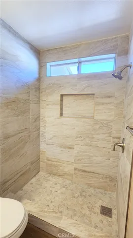 a bathroom with a toilet and a shower
