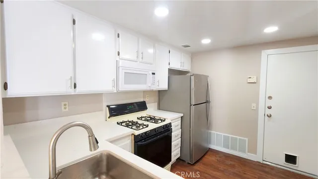 a kitchen with stainless steel appliances granite countertop a refrigerator and a stove top oven
