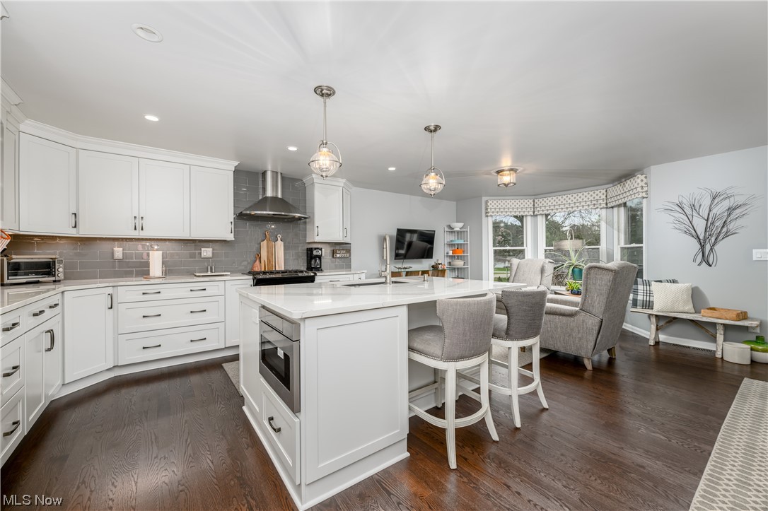 5304 Sibila Road Northwest Canton, OH 44718 - Photo 21 of 29 Kitchen with dark hardwood / wood-style flooring, stainless steel microwave, wall chimney range hood, and decorative light fixtures