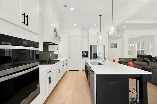 a kitchen with kitchen island a sink appliances and cabinets