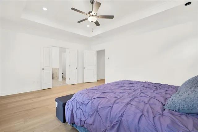 a spacious bedroom with a bed and a ceiling fan