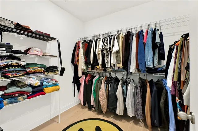 a view of walk in closet with clothes and shoes