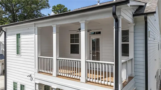 a view of a house with a small yard and a large tree
