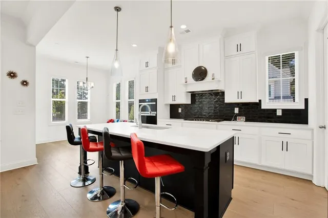a kitchen with a table chairs sink and cabinets