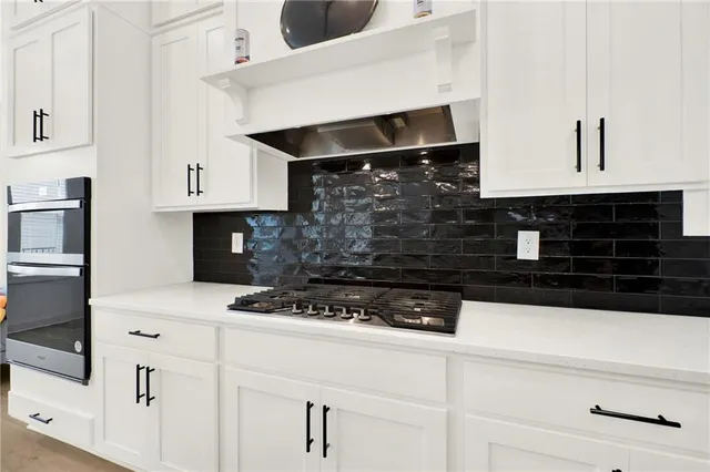 a kitchen with white cabinets and appliances