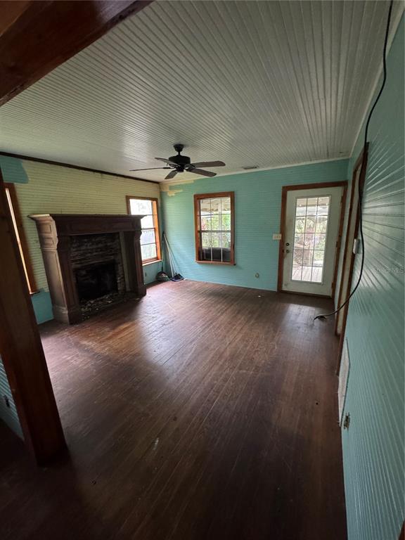 850 Menton Road Pierson, FL 32180 - Photo 7 of 35 an empty room with wooden floor fireplace and windows