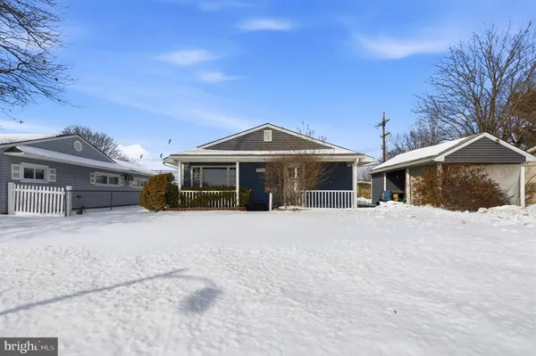 a front view of a house with a yard covered in snow