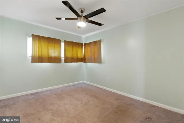 an empty room with a ceiling fan and a window
