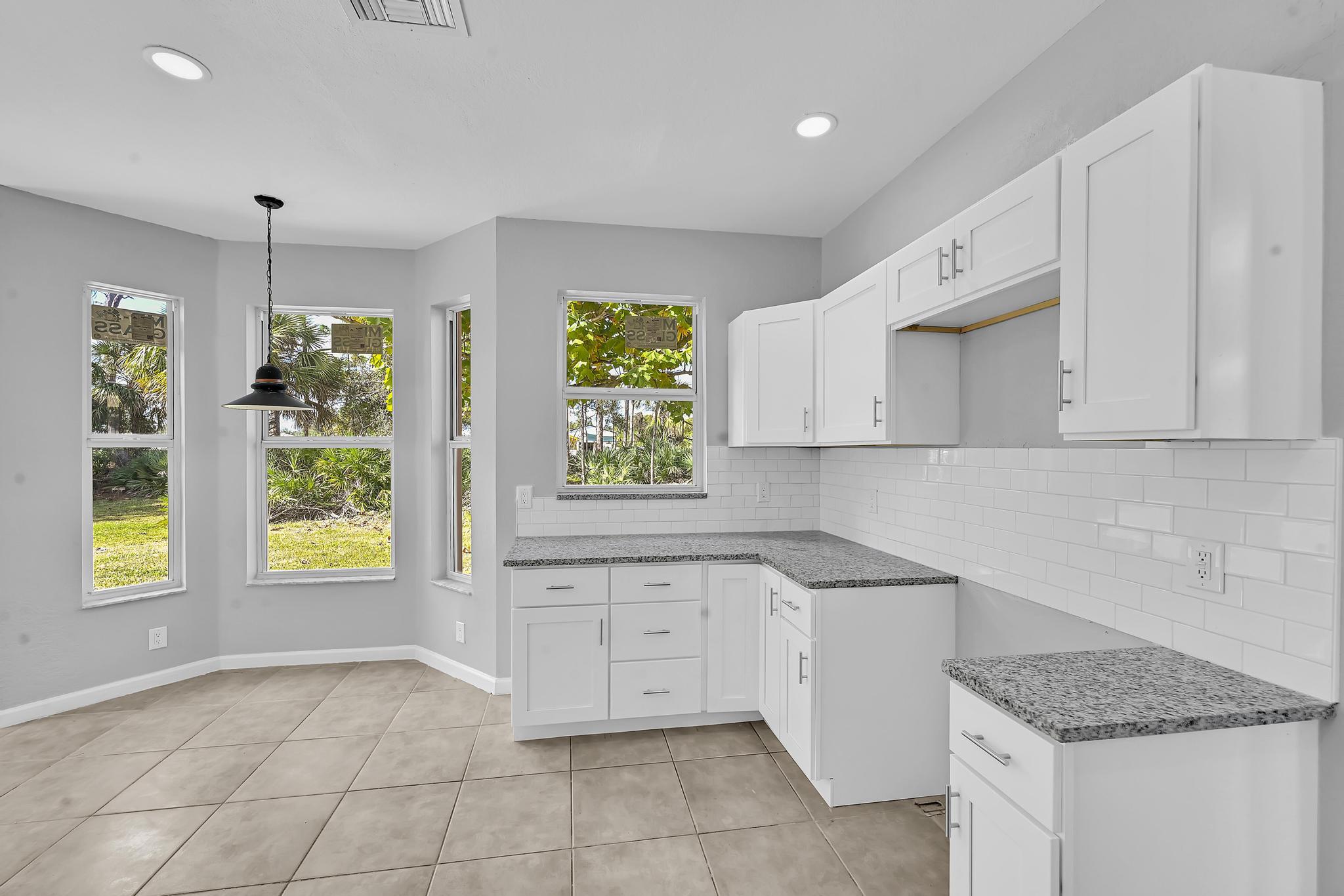 5557 Spanish River Road Fort Pierce, FL 34951 - Photo 11 of 28 a kitchen with a stove a sink and a window