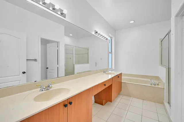 a spacious bathroom with a tub sink and mirror