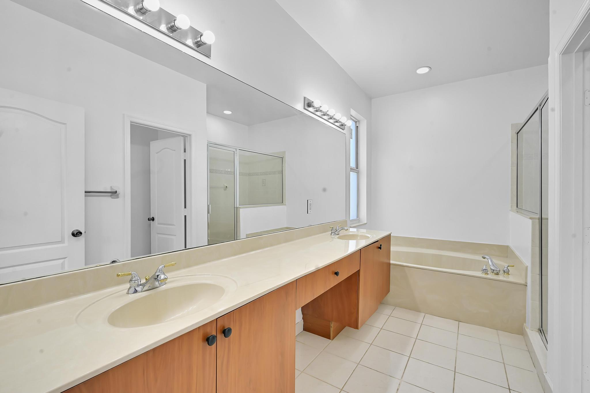 5557 Spanish River Road Fort Pierce, FL 34951 - Photo 18 of 28 a spacious bathroom with a tub sink and mirror