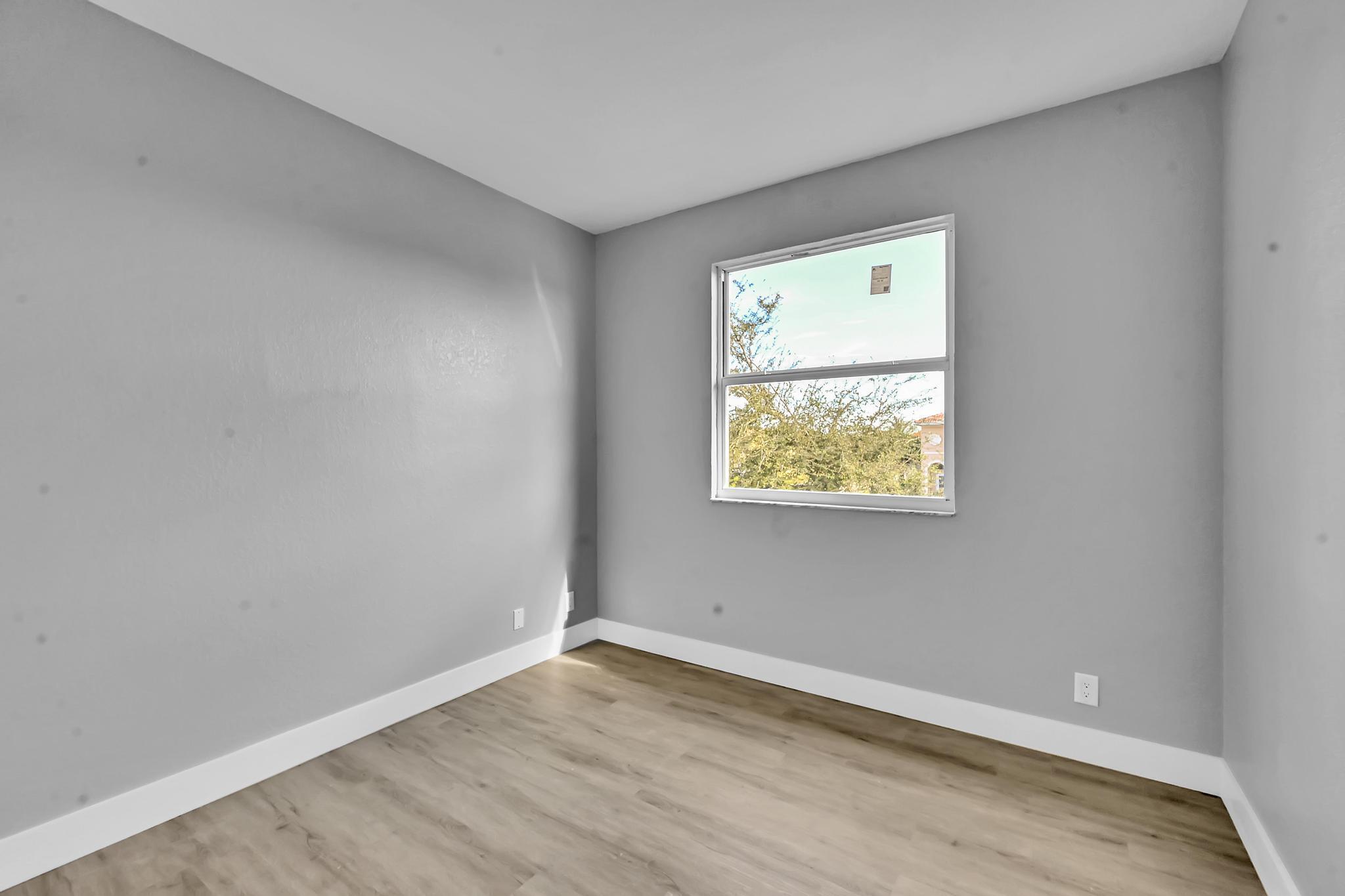 5557 Spanish River Road Fort Pierce, FL 34951 - Photo 21 of 28 a view of an empty room with wooden floor and a window