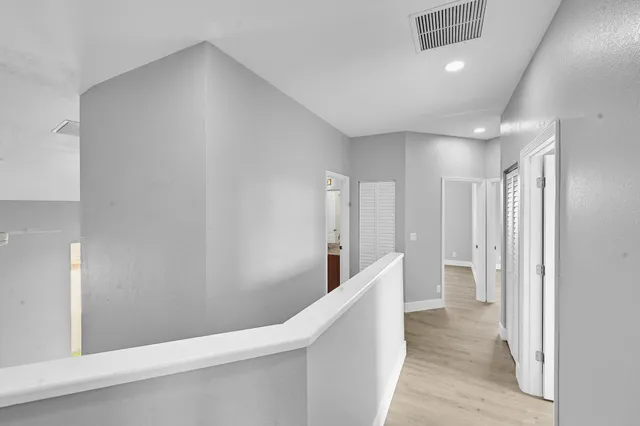 a view of a hallway with wooden floor