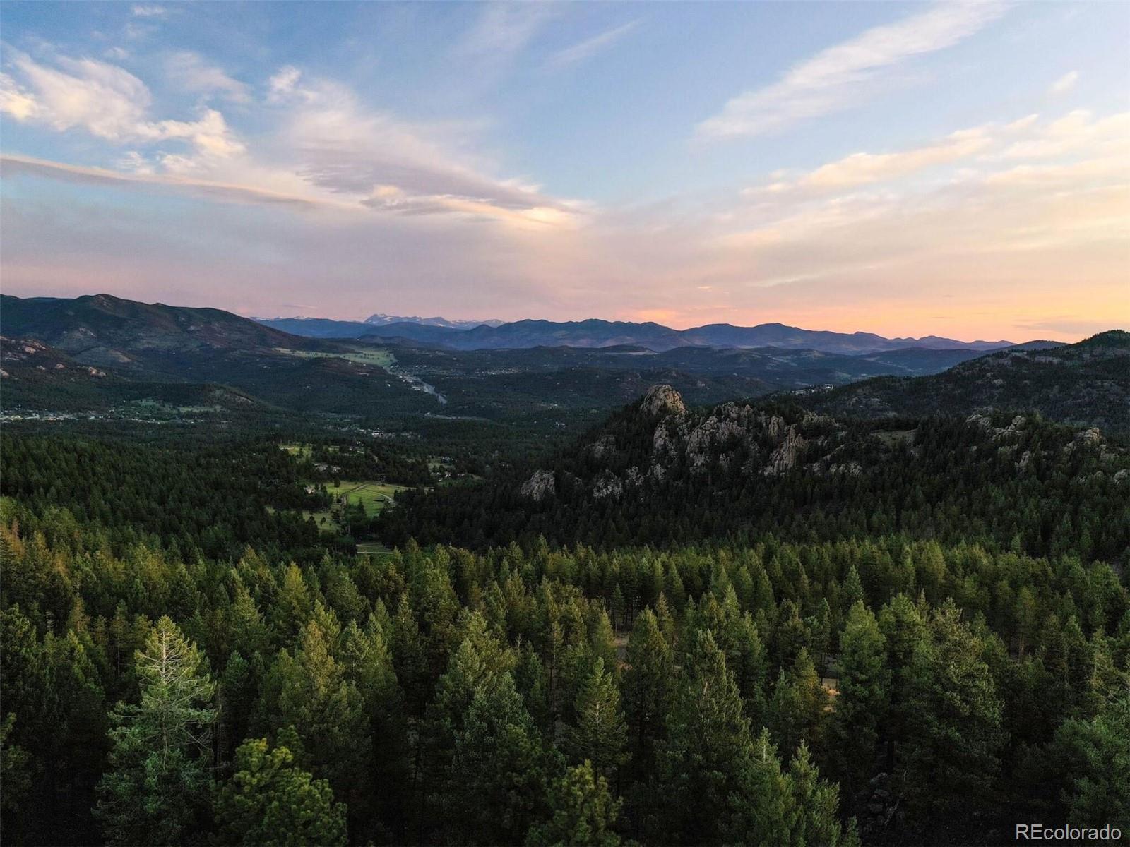 6371 Canyon Creek Road Evergreen, CO 80439 - Photo 2 of 50 a view of a lush green hillside and a houses