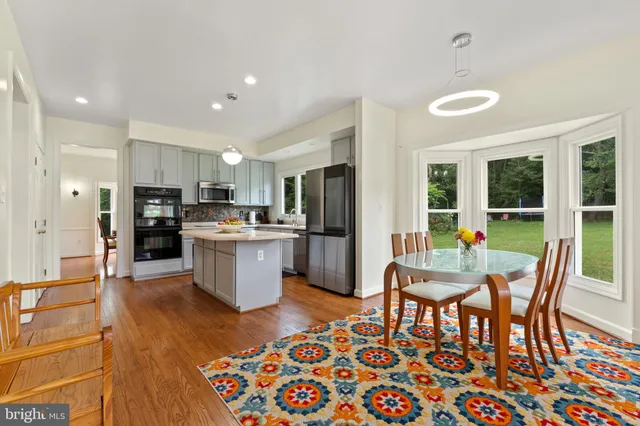 a dining room with furniture a chandelier and wooden floor