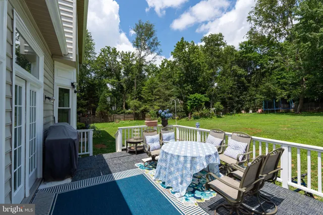 a view of a house with a big yard and large trees