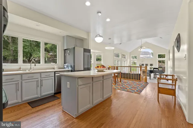 a large living room with stainless steel appliances granite countertop a couch and wooden floors