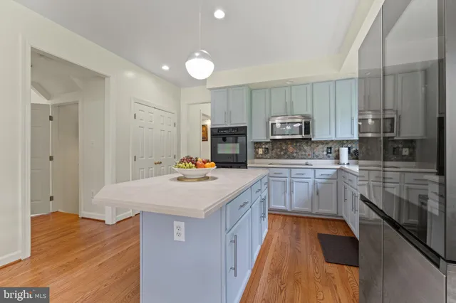 a kitchen with a dining table chairs and refrigerator