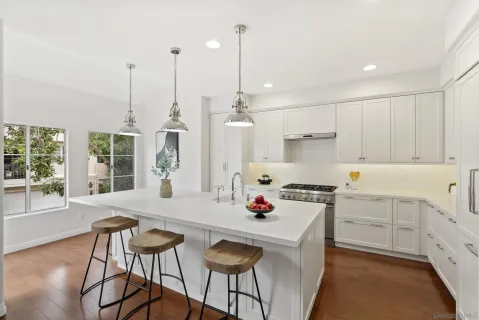 a kitchen that has a cabinets a stove a table and chairs in it