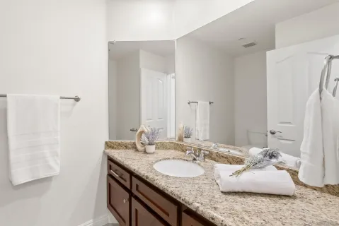 a bathroom with a granite countertop sink and a mirror