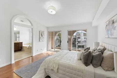 a large bedroom with a bed and wooden floor