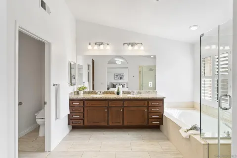 a spacious bathroom with a tub sink and mirror