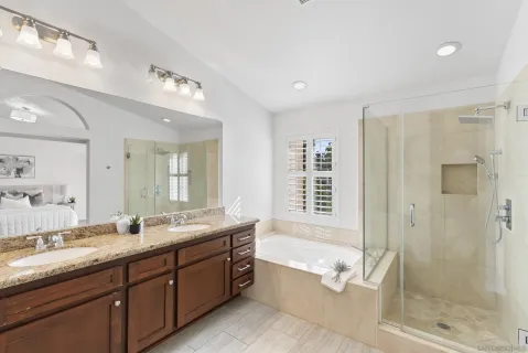 a spacious bathroom with sink shower bathtub and next to a window