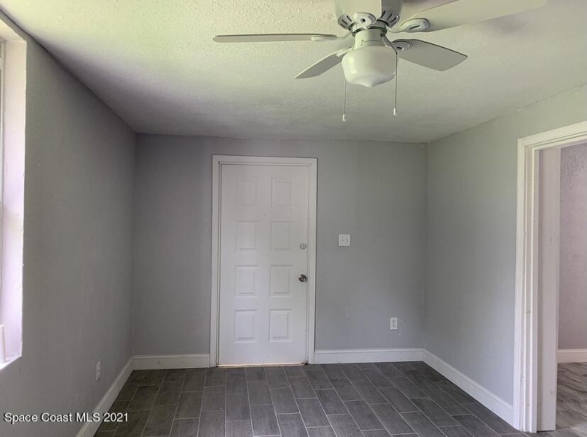 2806 Tropic Road Melbourne, FL 32935 - Photo 13 of 17 an empty room with a ceiling fan and wooden floor