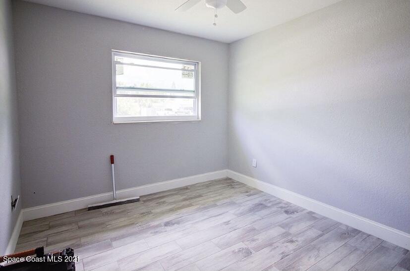 2806 Tropic Road Melbourne, FL 32935 - Photo 15 of 17 an empty room with wooden floor and windows