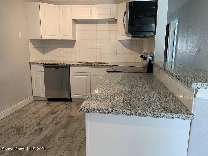 2806 Tropic Road Melbourne, FL 32935 - Photo 17 of 17 a kitchen with granite countertop a sink stainless steel appliances and cabinets