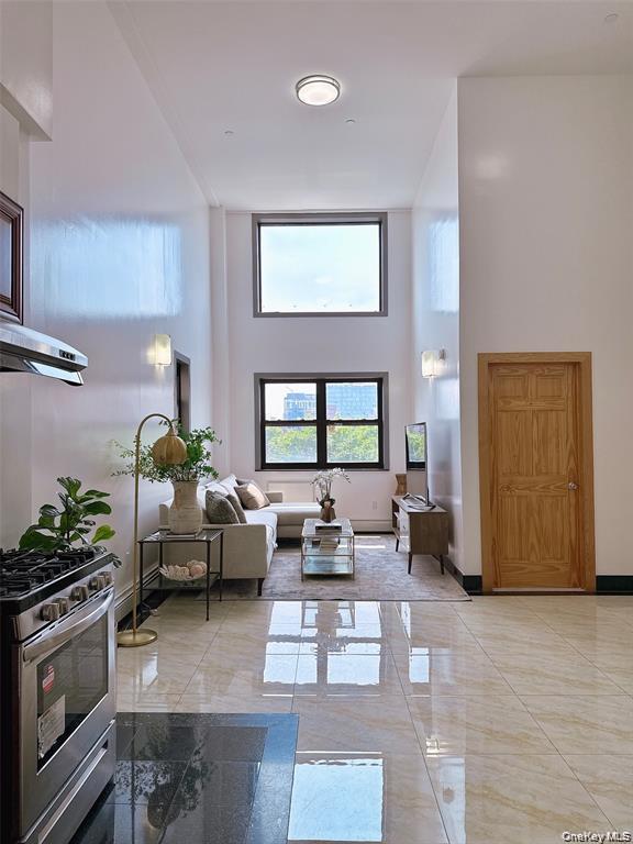 31-47 137th Street, Unit 4C Queens, NY 11354 - Photo 3 of 11 Living area featuring a towering ceiling and baseboards