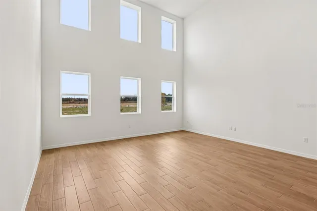 a kitchen with stainless steel appliances granite countertop a sink a stove a refrigerator and white cabinets with wooden floor