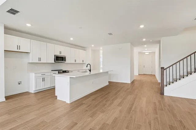 a spacious kitchen with stainless steel appliances granite countertop a sink and cabinets