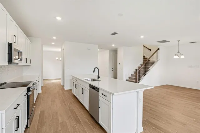 a kitchen with stainless steel appliances granite countertop a sink a stove and a refrigerator