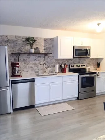 a kitchen with stainless steel appliances granite countertop a stove and a sink