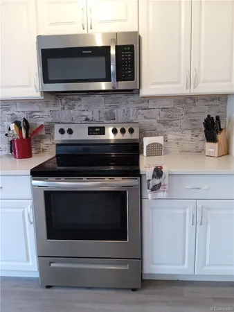 a kitchen with stainless steel appliances granite countertop a stove and a microwave