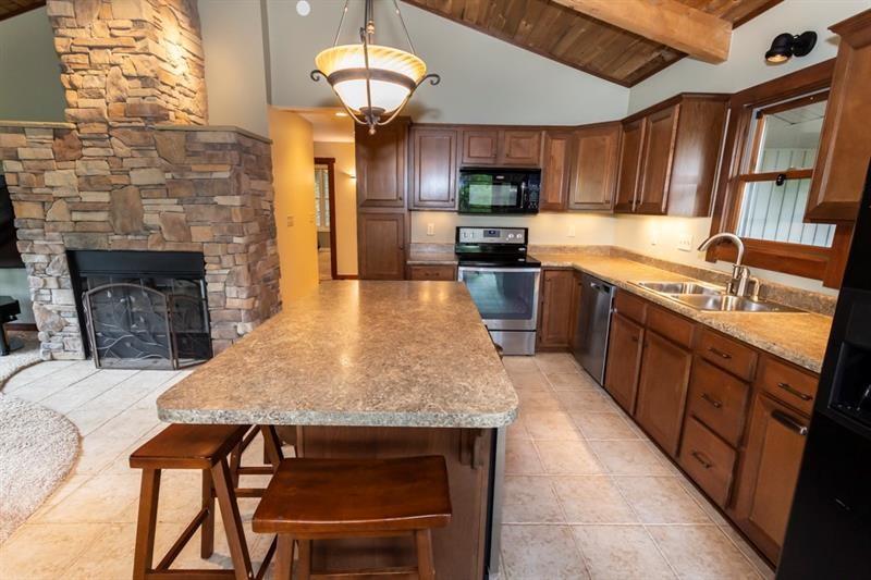 2226 County Line Road Champion, PA 15622 - Photo 6 of 33 a kitchen with stainless steel appliances granite countertop a kitchen island hardwood floor sink stove dining table and chairs