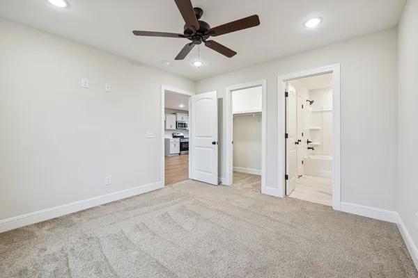 an empty room with closet and a ceiling fan