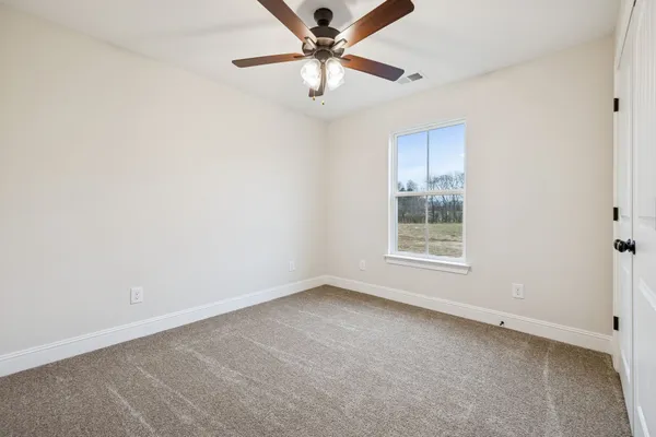 an empty room with a window and a fan