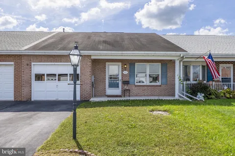 a view of a house with a yard and a large tree